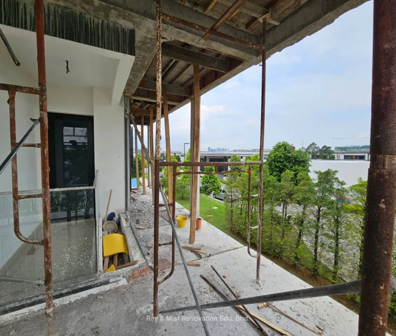View of a partially renovated upper floor with exposed scaffolding and greenery in the background —Project by Ray & Mist Renovation Sdn. Bhd.