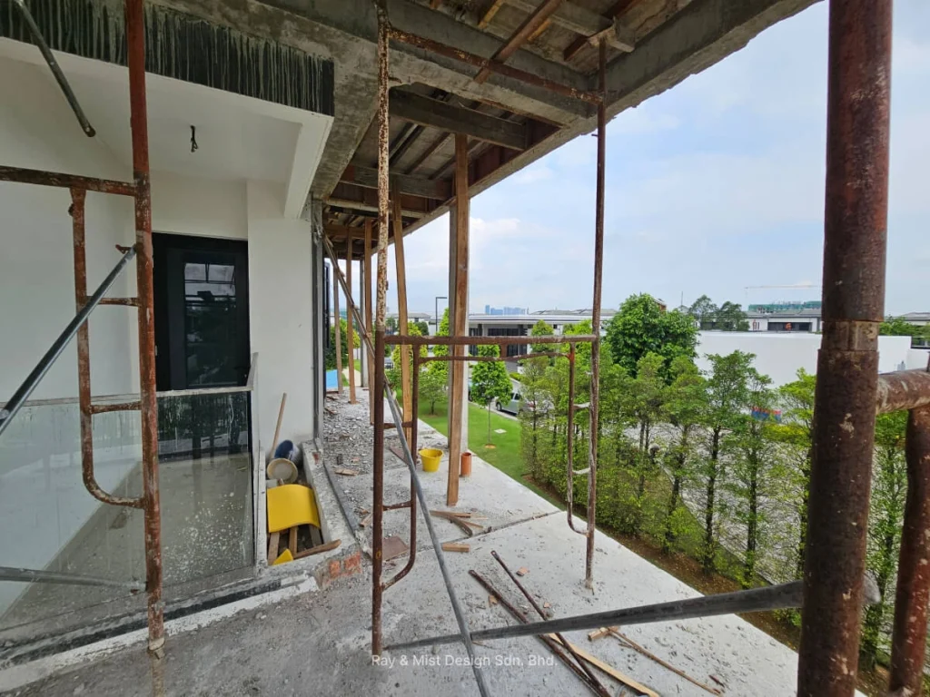 View of a partially renovated upper floor with exposed scaffolding and greenery in the background —Project by Ray & Mist Renovation Sdn. Bhd.