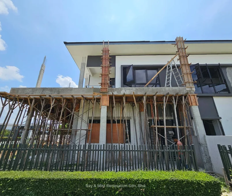 Front view of ongoing structural renovation with scaffolding and exposed concrete columns —Project by Ray & Mist Renovation Sdn. Bhd.