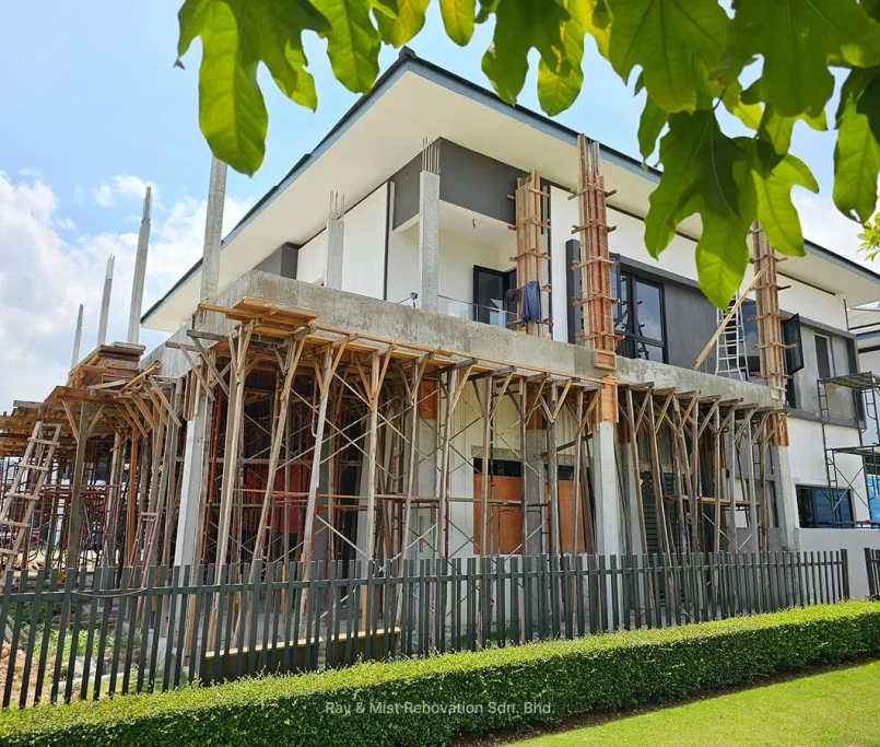 Angled view of house renovation with extensive scaffolding and formwork on concrete columns —Project by Ray & Mist Renovation Sdn. Bhd.