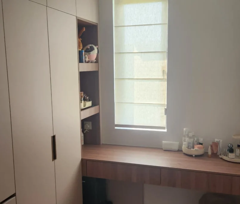 Custom built-in wardrobe with vanity counter beside a shaded window —Project by Ray & Mist Renovation Sdn. Bhd.