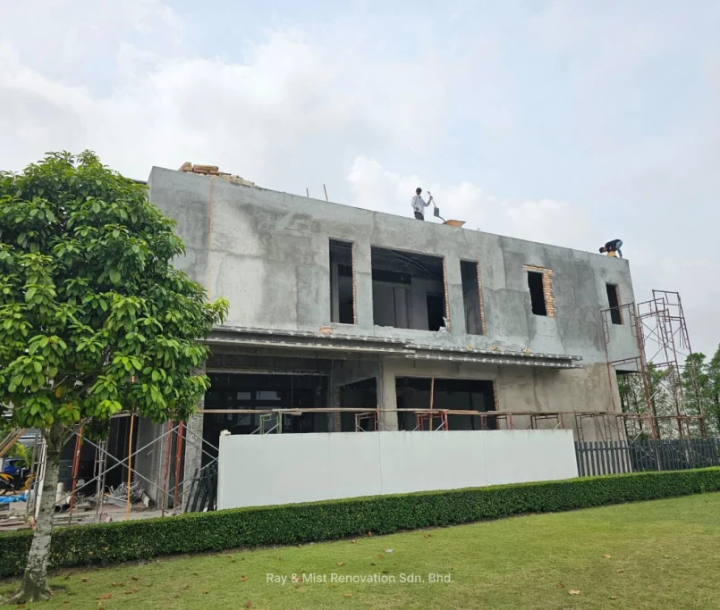 Two-storey house in early renovation phase with unpainted cement walls and workers on the roof —Project by Ray & Mist Renovation Sdn. Bhd.