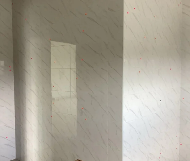 Kitchen corner with marble tile walls marked for cabinet installation —Project by Ray & Mist Design Sdn. Bhd.