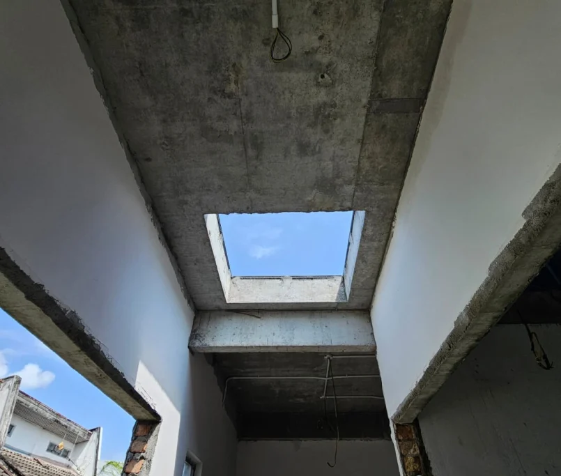 Partially completed interior hallway with a square skylight opening in the concrete ceiling — Project by Ray & Mist Renovation Sdn. Bhd.