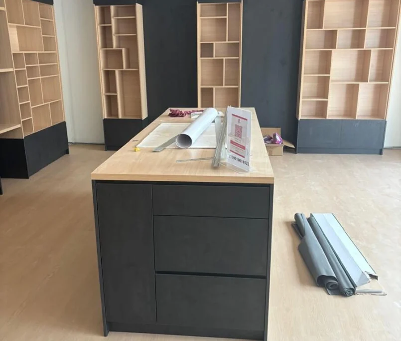 Custom-built black and wood display shelves with centre island cabinet in a modern retail space—Project by Ray & Mist Renovation Sdn. Bhd.