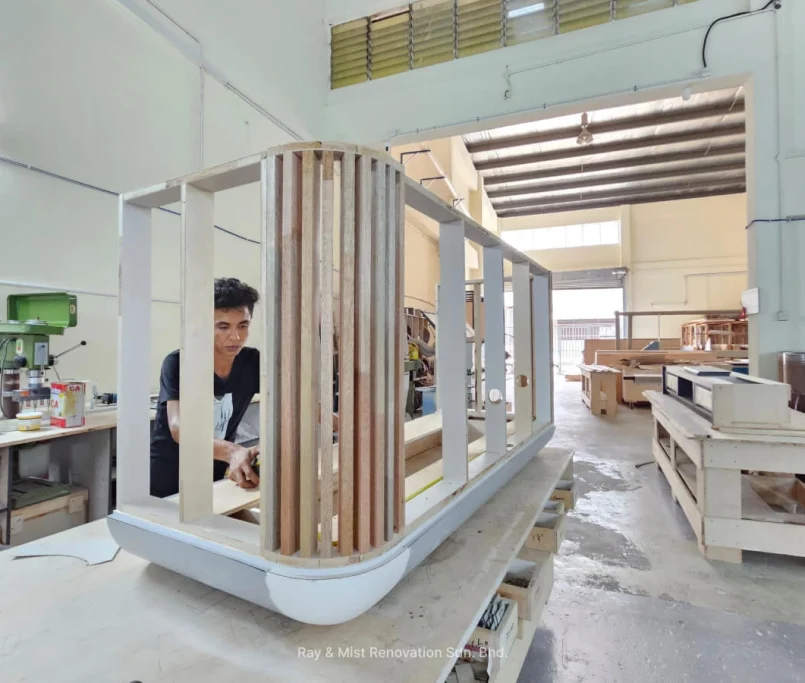Two craftsmen working on a curved wooden cabinet frame in a workshop —Project by Ray & Mist Design Sdn. Bhd.