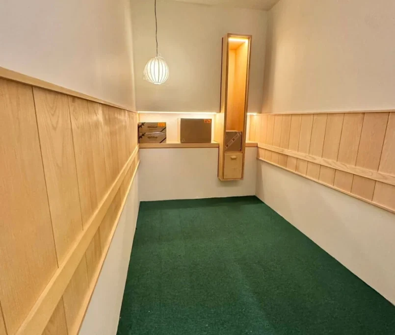 Narrow room with green carpet, wood wall paneling, and built-in display lighting —Project by Ray & Mist Design Sdn. Bhd.