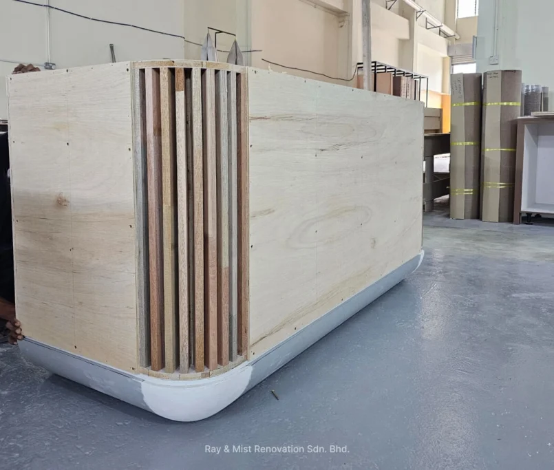 Craftsman installing curved plywood cladding on a custom cabinet frame —Project by Ray & Mist Design Sdn. Bhd.