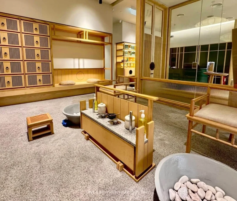 Japanese-inspired spa foot soak area with wooden chairs, stone basins, and open shelves —Project by Ray & Mist Design Sdn. Bhd.