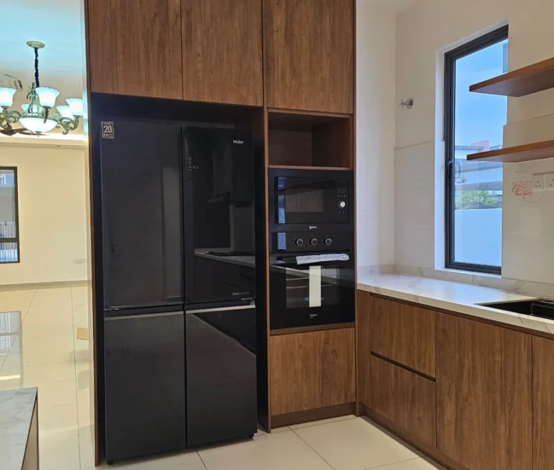 Kitchen corner with built-in black refrigerator, oven, microwave, and wood cabinetry —Project by Ray & Mist Renovation Sdn. Bhd.