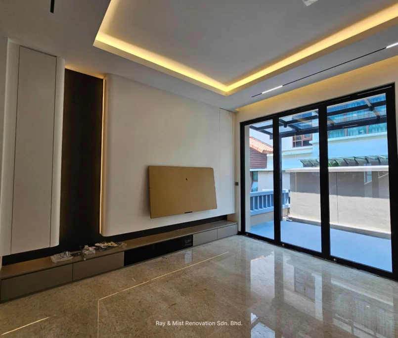 Modern living room with recessed ceiling lights, built-in TV panel, and sliding glass doors — Project by Ray & Mist Renovation Sdn. Bhd.