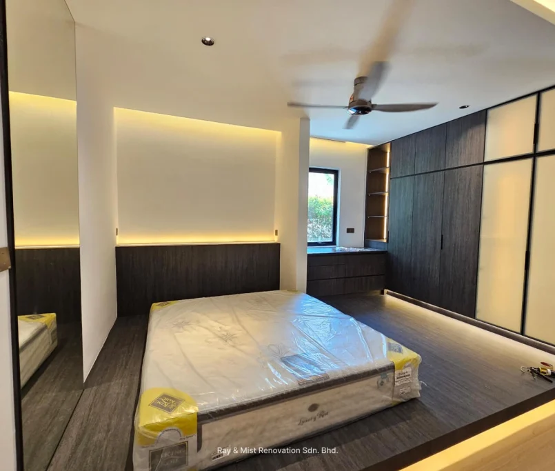 Modern bedroom with raised platform flooring, dark wood cabinetry, and ambient lighting — Project by Ray & Mist Renovation Sdn. Bhd.