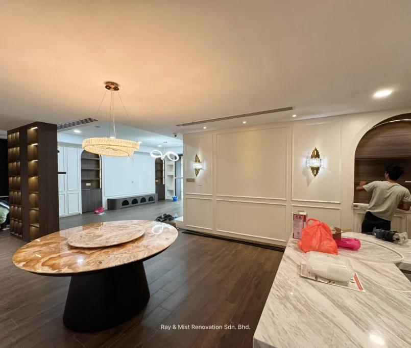 Open-plan living and dining area with marble dining table, paneled walls, and built-in cabinetry — Project by Ray & Mist Renovation Sdn. Bhd.