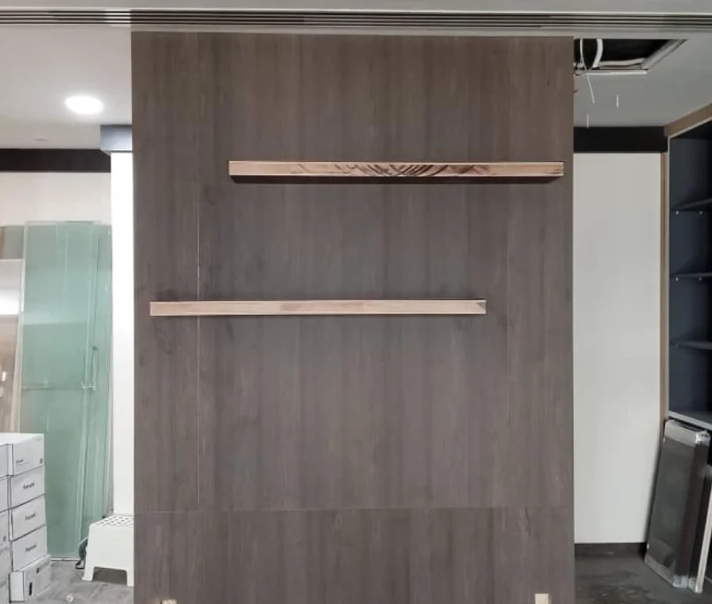 Dark wood panel wall with two floating wooden shelves during interior renovation — Project by Ray & Mist Renovation Sdn. Bhd.