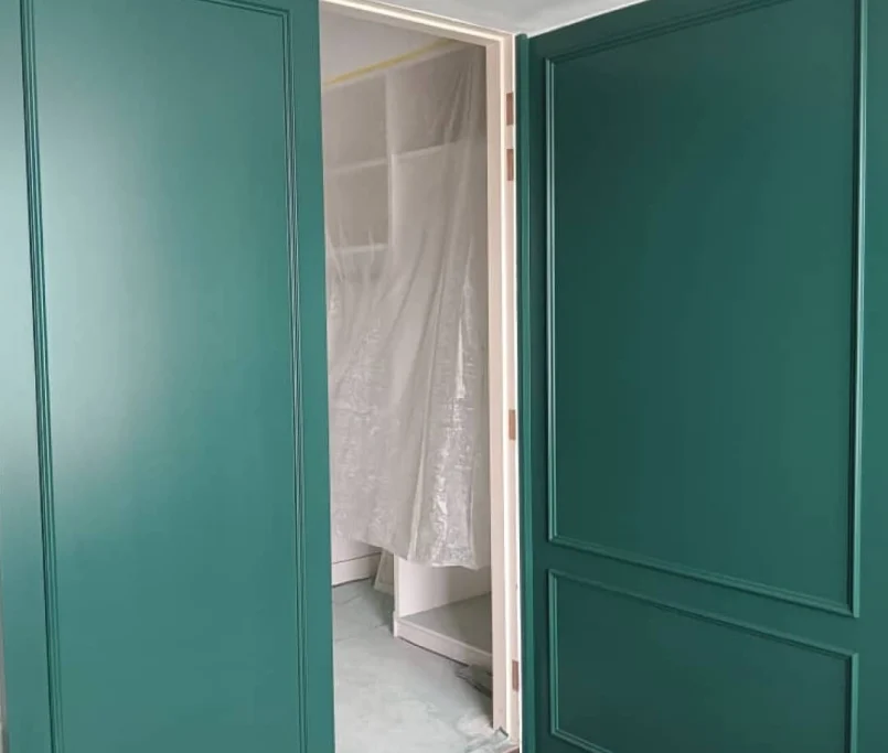 Double swing doors in emerald green with classic panel detailing, partially open to reveal a room under renovation — Project by Ray & Mist Renovation Sdn. Bhd.